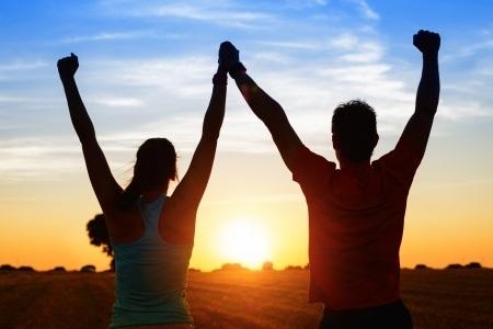 Encourage your Clients to be Less Sedentary with Weekly Fitness Challenges 2 successful couple of young athletes raising arms