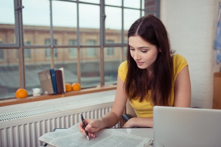 woman looking at newspaper research