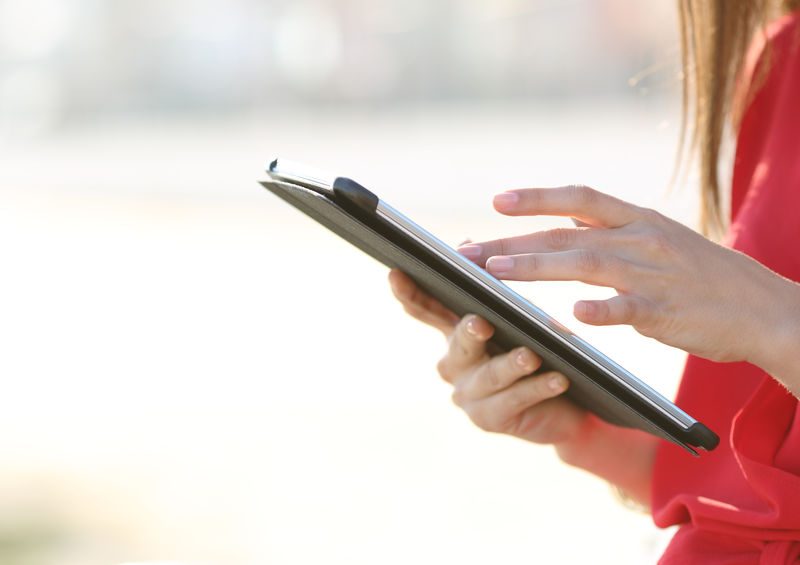 Woman Hands Browsing A Tablet Outdoors