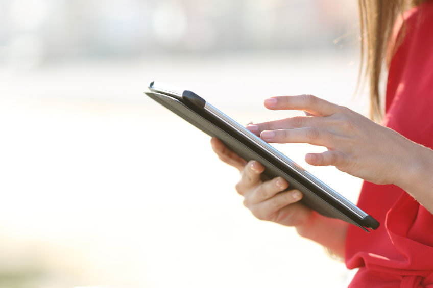 Woman Hands Browsing A Tablet Outdoors