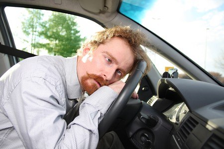 drowsy man on car steering wheel