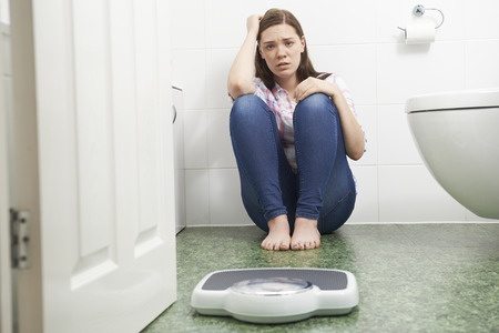 woman on floor in front of scale