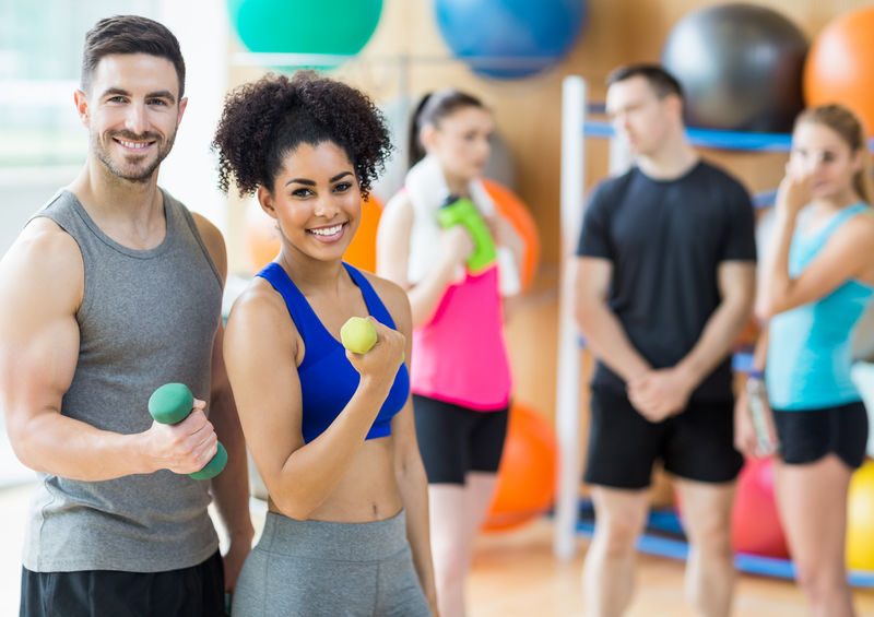 Client And Trainer Smiling At Camera At The Gym