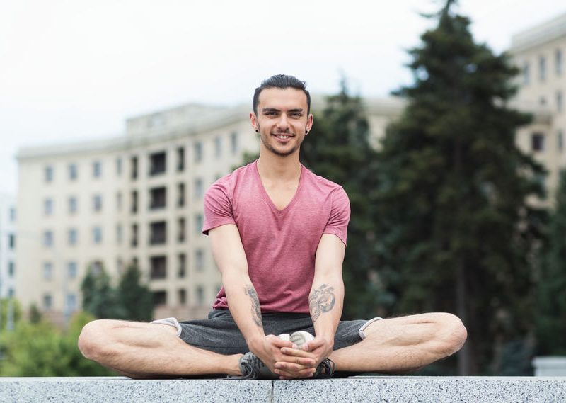 Portrait Of Young Men Doing Butterfly Yoga Pose Outdoors