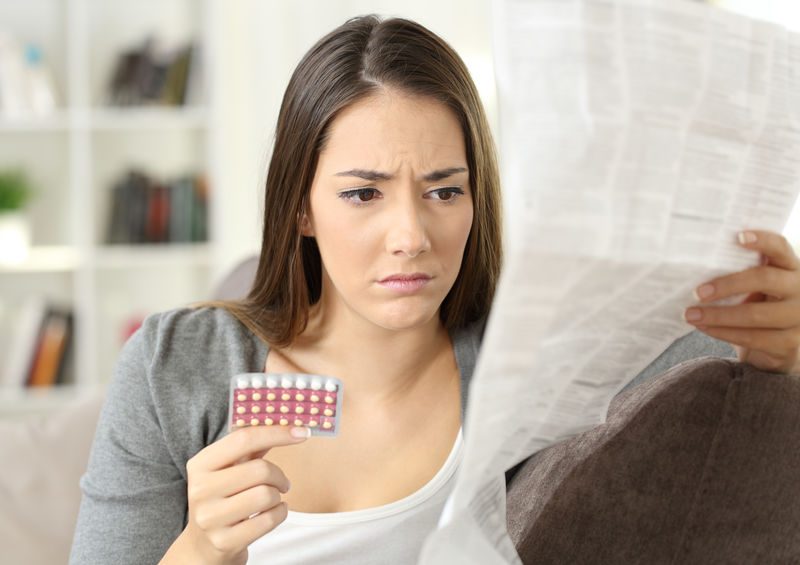 Worried Woman Reading Contraceptive Pills Leaflet