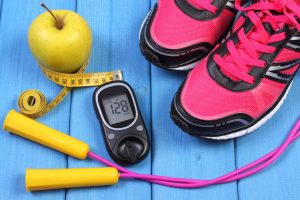 Glucometer, Sport Shoes, Fresh Apple And Accessories For Fitness On Blue Boards
