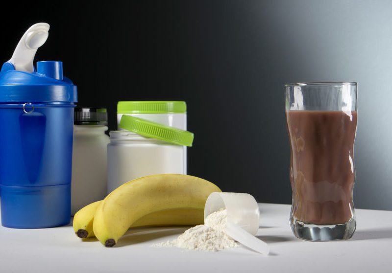 Fueling For Success: Pre and Post Workout Meals 2 Supplement Containers With Glass Of Cocktail